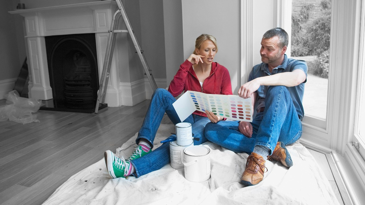 A couple choosing paint colour for their new house; image used for HSBC Australia Remodeling your empty nest: top tips for transforming your space.